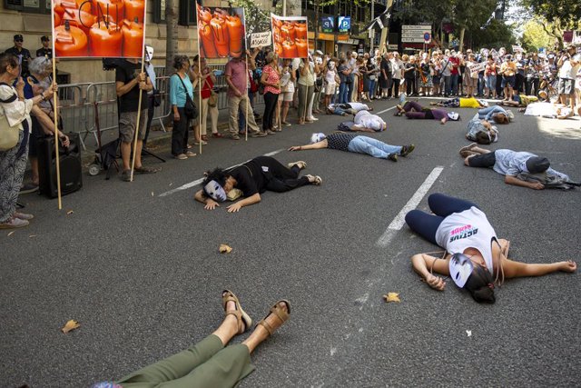 Diverses persones es tomben en el sòl com si anessin algunes de les víctimes dels atemptats durant una concentració convocada per la plataforma 17A enfront de la Delegació de Govern, a 17 d'agost de 2023, a Barcelona, Catalunya (Espanya).