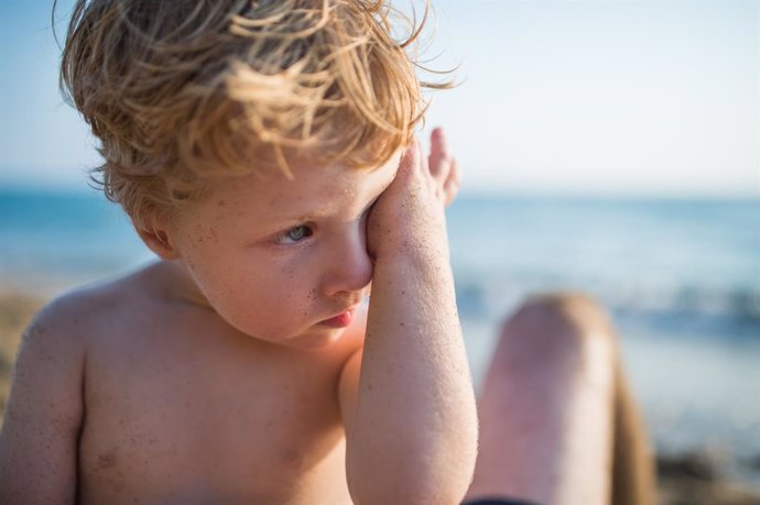 Archivo - Niño en la playa rascándose el ojo