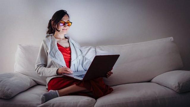 Archivo - Mujer usando el ordenador con gafas que filtran la luz azul.