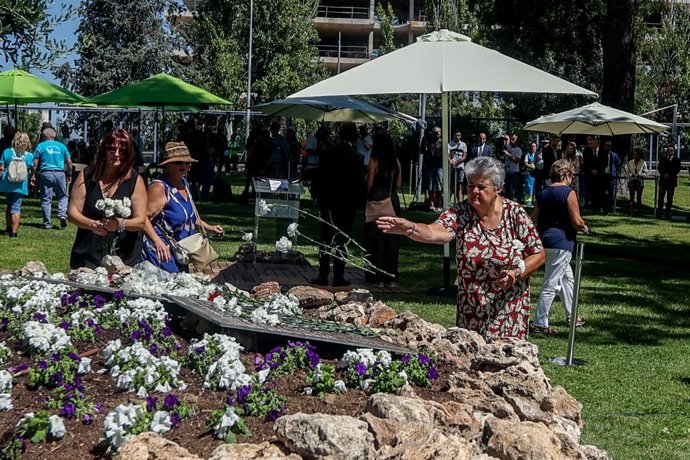 Archivo - La presidenta de la Asociación de Afectados del Vuelo de Spanair JK5022, Pilar Vera, echa flores en el olivo con las placas que tienen los nombres de los fallecidos del accidente de Spanair, en la Terminal 2 del aeropuerto, a 20 de agosto de 2