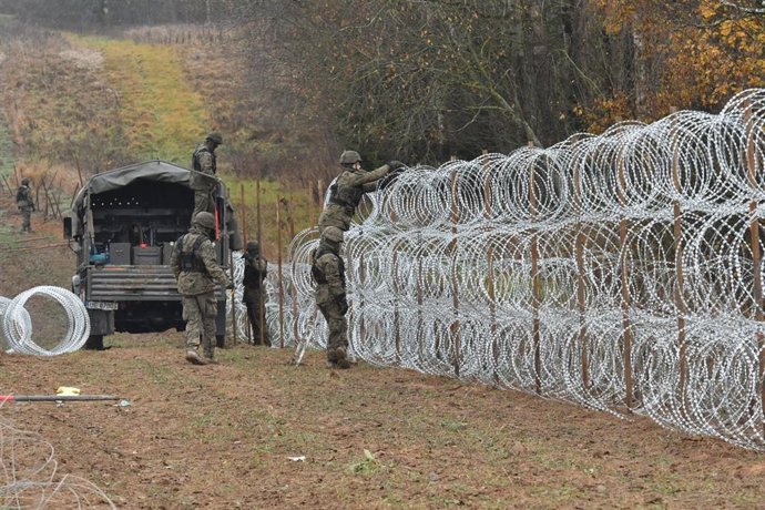 Archivo - Soldados polacos levantan una valla de alambre en la frontera con Bielorrusia.