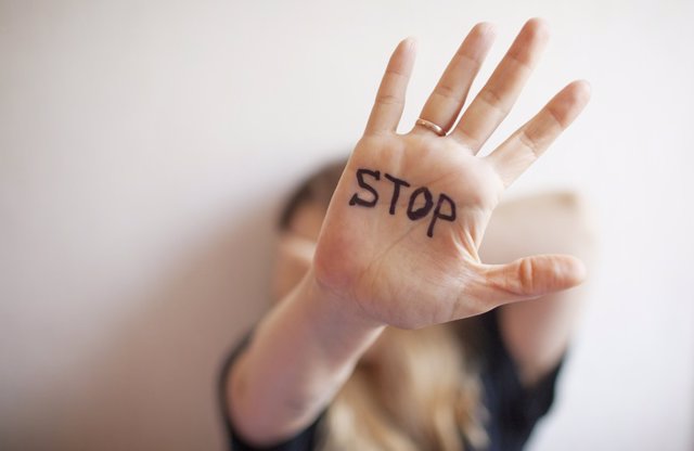 Archivo - Mujer muestra palma con la inscripción en la palma "Stop"