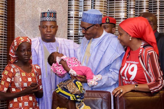 Archivo - El entonces presidente de Nigeria Muhamadu Buhari se reúne con una de las niñas liberadas en Chibok 