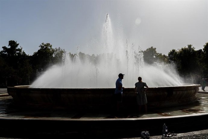 Turistas se refrescan en la fuente de la Plaza de España (Sevilla), en imagen de archivo.