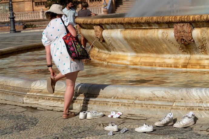 Turistas se refrescan en la fuente de la Plaza de España durante una ola de calor, en foto de archivo. 