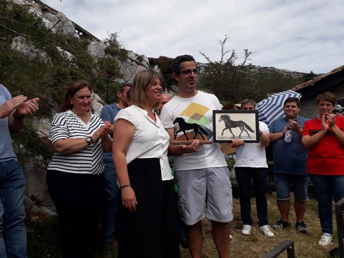 La vicepresidenta y consejera de Presidencia, Reto Demográfico, Igualdad y Turismo, Gimena Llamedo, entrega el Asturcón de Oro a un representante de Caja Rural de Asturias, la entidad que recibe el máximo galardón en 2023.