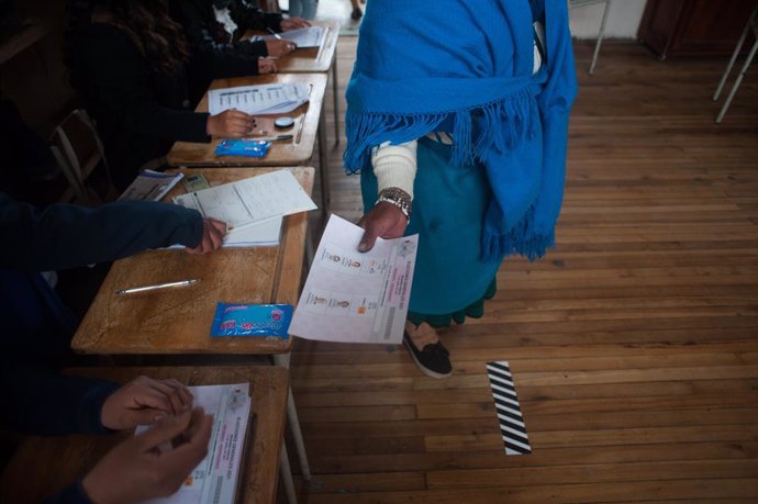 Archivo - April 11, 2021, Quito, Ecuador: An indigenous woman receives her voting ballot after signing the voters lists..In the Cancaghua indigenous parish near Cayambe in the province of Pichincha, people from different communities move to jose antonio