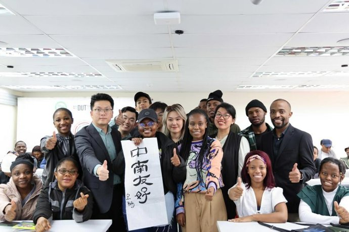 Sanele Ntuli (2nd R), a mandarin teacher at the Confucius Institute at Durban University of Technology, poses for a photo with faculty and students with a calligraphic work showing "China-South Africa Friendship" in Durban, South Africa, August 18, 2023