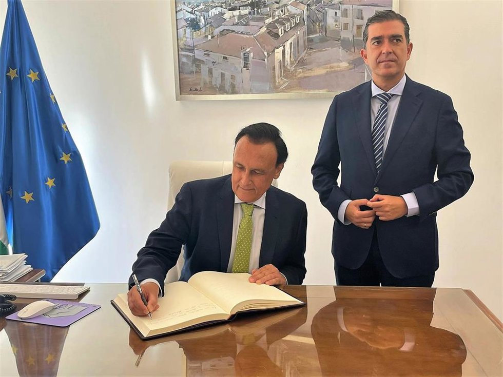 Villamandos firma en el libro de honor del Ayuntamiento de Baeza en presencia del alcalde.