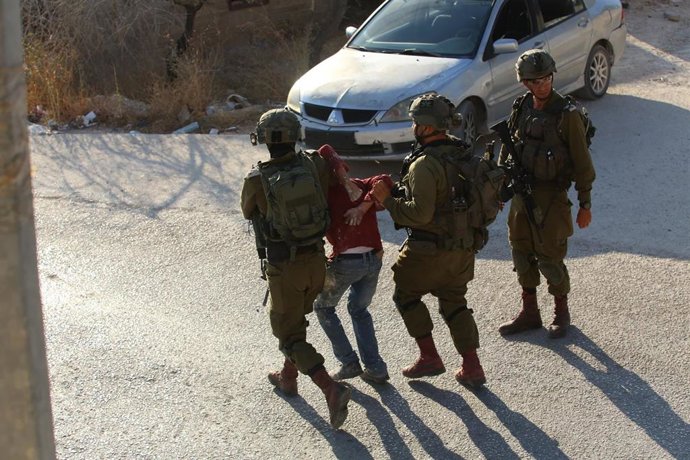 Imagen de archivo de soldados israelíes deteniendo a un palestino durante una redada israelí en Cisjordania