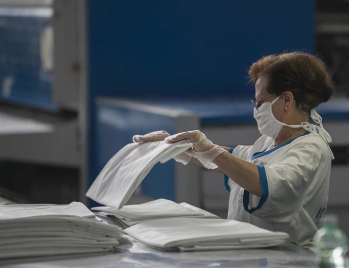 Una trabajadora durante el proceso de empaquetado en una lavandería.