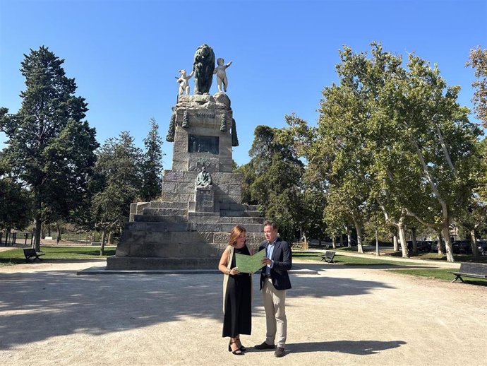 Sara Fernández y Víctor Serrano frente al monumento en el Parque Grande