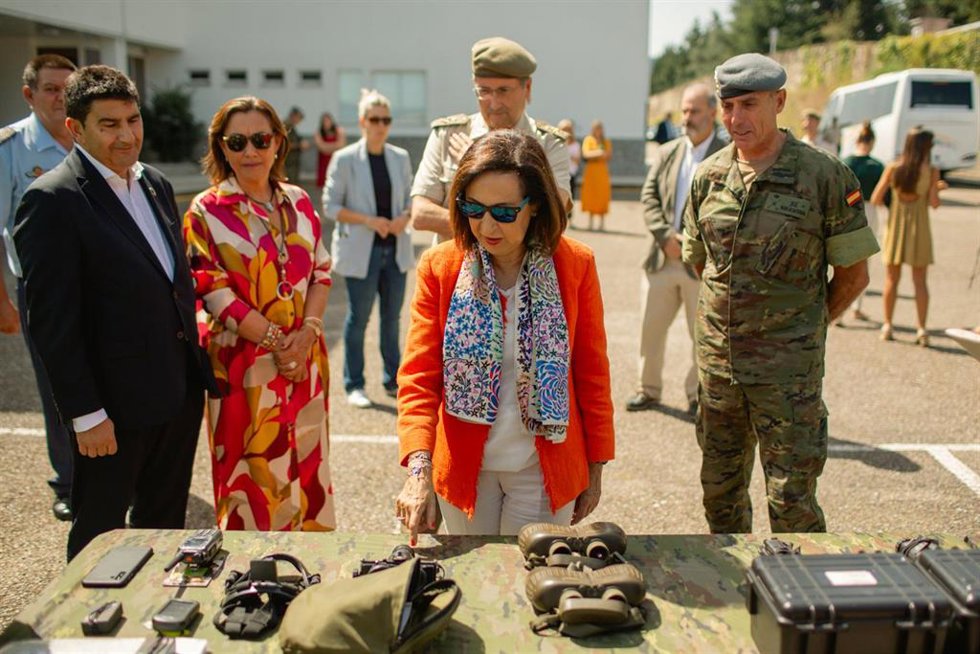 La ministra de Defensa en funciones, Margarita Robles (2d), observa algunos prismáticos situados encima de una mesa durante su visita a los componentes de la Brigada 'Galicia' VII Brilat en su Base 'General Morillo', a 21 de agosto de 2023, en Vilaboa, 