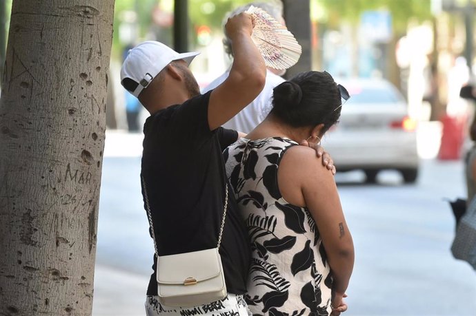 Una pareja abanicándose