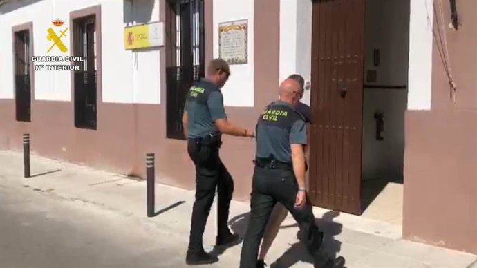 Los agentes conducen a uno de los arrestados a dependencias de la Guardia Civil.