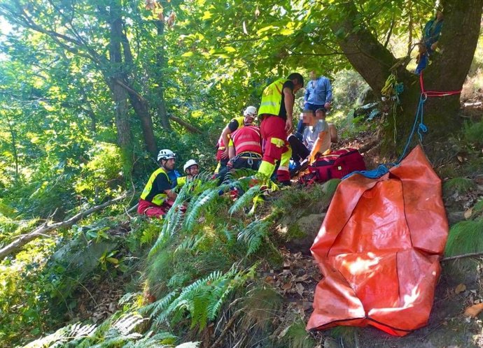 Efectivos del helicóptero del Gobierno de Cantabria atienden a un vecino de Los Corrales de Buelna que sufrió una fractura de tibia y peroné al caerle un tronco encima cuando estaba cortando leña
