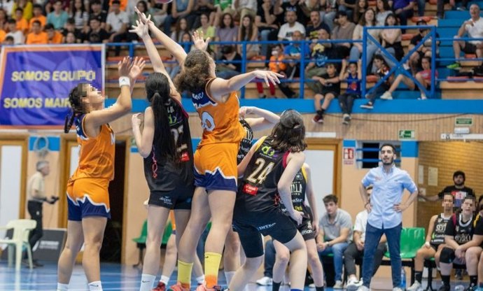 Jóvenes deportistas disputan un partido de baloncesto en un pabellón de la localidad.