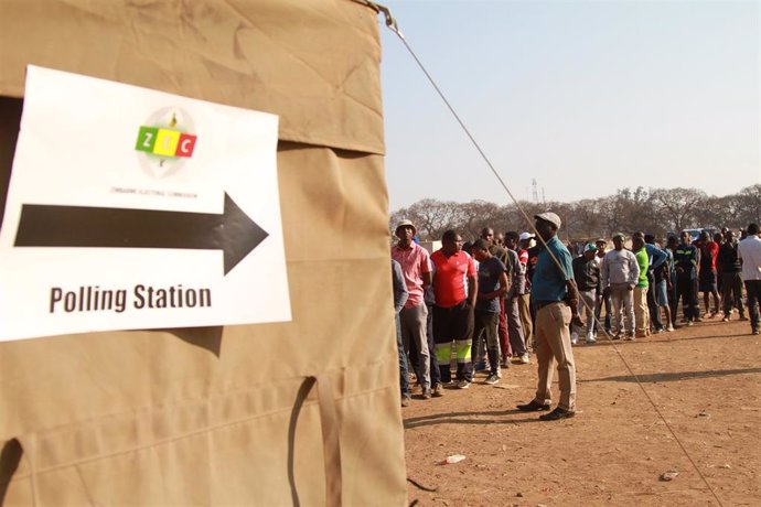 Un grupo de votantes hace cola en un colegio electoral de Harare, capital de Zimbabue