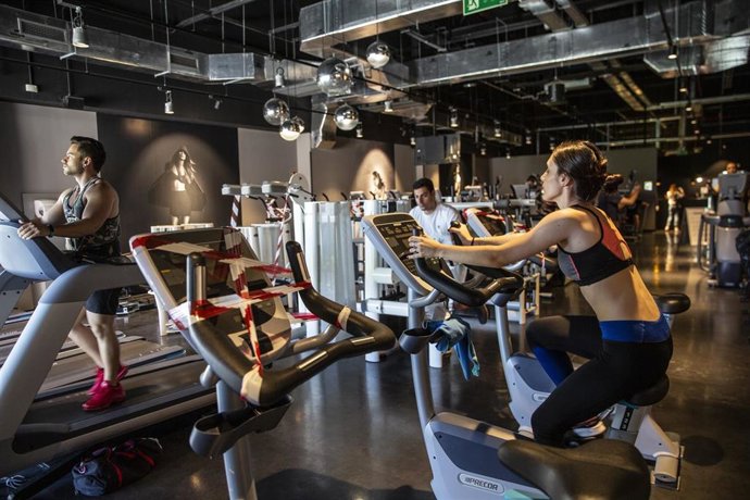 Archivo - Varias personas realizan ejercicio en un gimnasio. 