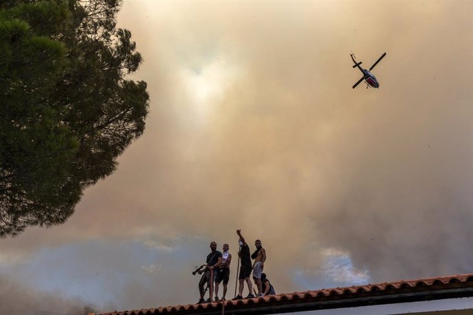 ATHENS, Aug. 23, 2023  -- Volunteers try to control a wildfire near Athens, Greece, on Aug. 23, 2023. Wildfires raging around Greece's capital spread to the Mount Parnitha National Park, northwest of Athens, on Wednesday, the Fire Brigade said. The blaze 