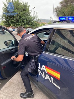 Archivo - Agente de la Policía Nacional entrando en un vehículo