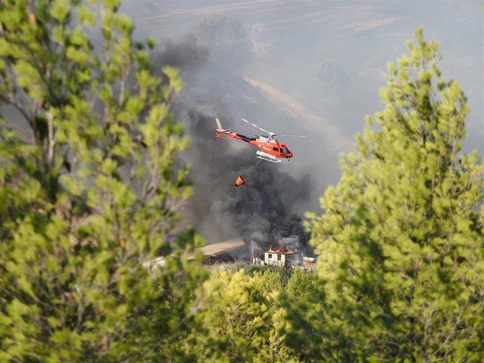 Un helicóptero trabaja en las tareas de extinción del incendio forestal declarado el jueves por la tarde en Artajona (Navarra).