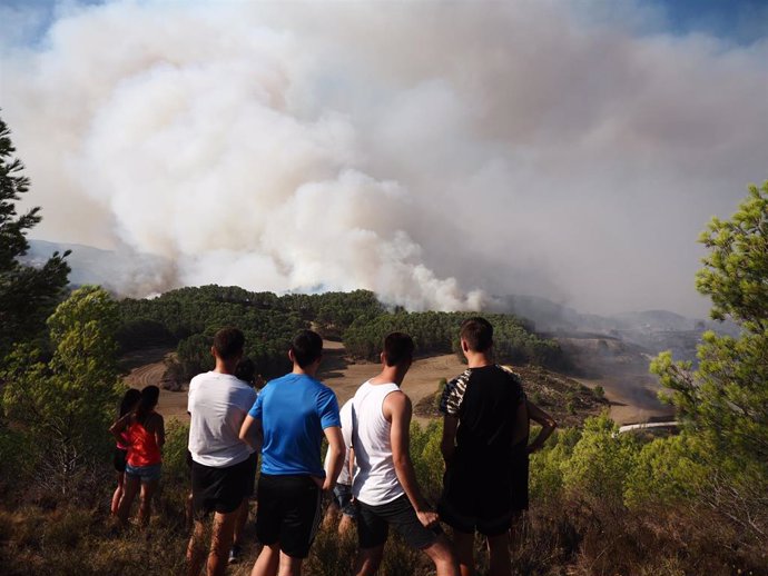 Varios civiles observan la progresión del incendio, a 24 de agosto de 2023, en Artajona, Navarra (España). Bomberos de los parques de Tafalla, Cordovilla, Peralta y Estella, dos helicópteros y dos aviones de carga en tierra intervienen en el incendio fo