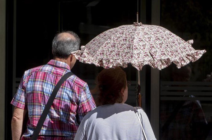 Una mujer pasea con paraguas para protegerse del calor en Madrid (España)