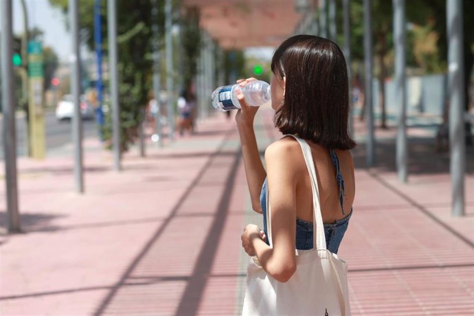 Una joven bebe agua para refrescarse ante las altas temperaturas