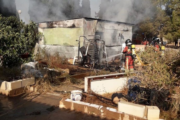 Bomberos de Cartagena sofocan un incendio originado en una vivienda prefabricada en el paraje de Los Navarros, en la diputación de La Aljorra