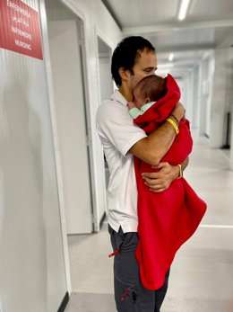 Voluntario de Cruz Roja atiente al bebé de menos de dos meses llegado en patera este sábado a Calp (Alicante)