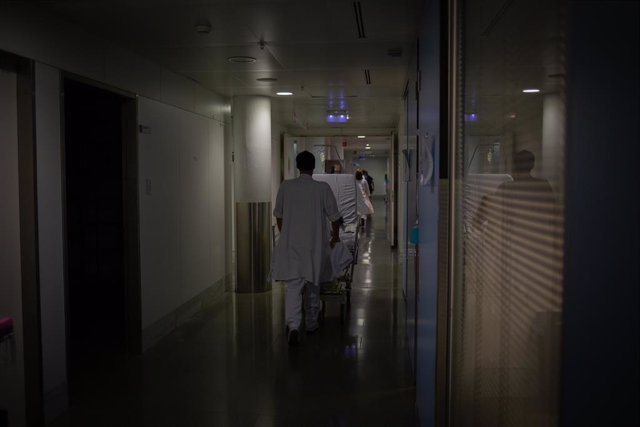 Archivo - Professional sanitari trasllada un llit mòbil a la UCI de l'Hospital de la Santa Creu i Sant Pau (Barcelona)