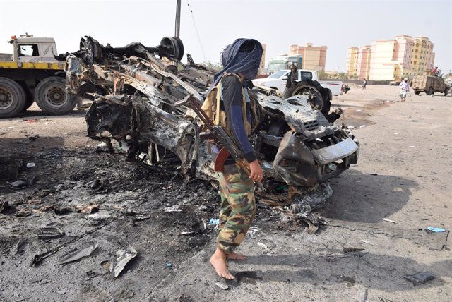 Archivo - ADEN, March 25, 2022  -- A security officer stands next to the wreckage of a car on a street of Aden, the southern port city of Yemen, on March 24, 2022. A deadly booby trap bomb attack in southern Yemen's Aden killed a high-ranking military com