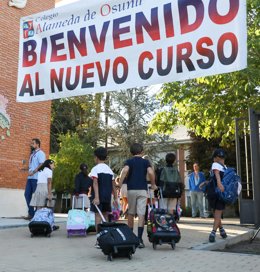 Archivo - Varios niños entran por el patio el día de inicio del curso