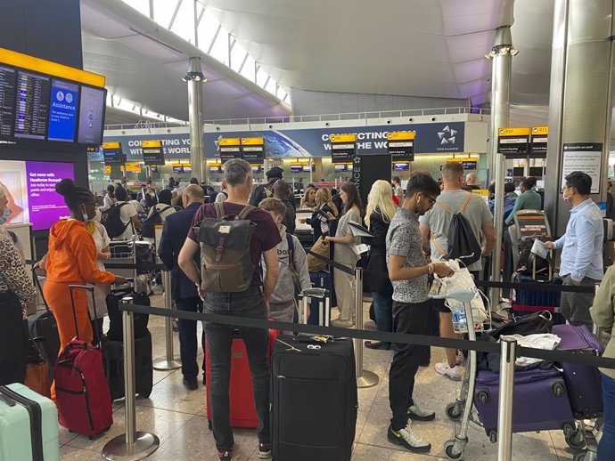 Archivo - FILED - 25 July 2022, United Kingdom, London: Passengers queue to check-in at terminal 2 of Heathrow Airport. Photo: Steve Parsons/PA Wire/dpa