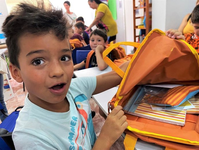 Imagen de un niño con material escolar.