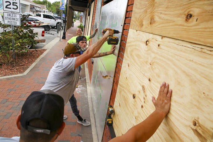 August 29, 2023, Crystal River, Florida, USA: JAMIE DAVIS, of Gainesville, center, secures a sheet of plywood on the entrance of St. Johns Tavern with the help of CODY RANDALL, of High Springs, ZACHARY JOHNSON, of Lake City, far, and JEREMY ONORATO, of 