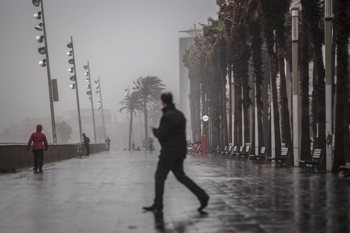 Archivo - Arxivo - Un home camina pel passeig marítim de Barcelona, en una imatge d'arxiu