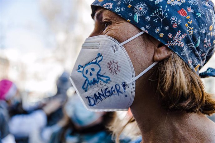 Archivo - Una sanitaria con una mascarilla durante una manifestación