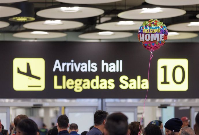 Archivo - Un grupo de personas a su salida de la puerta de llegadas de la terminal T4 del aeropuerto de Adolfo Suárez-Madrid Barajas