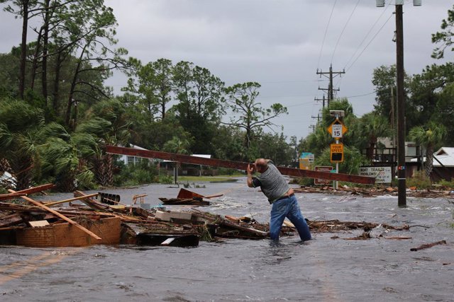 August 30, 2023: Jeff Erickson hoists the debris blocking authorities from entering Horseshoe Beach, Florida.