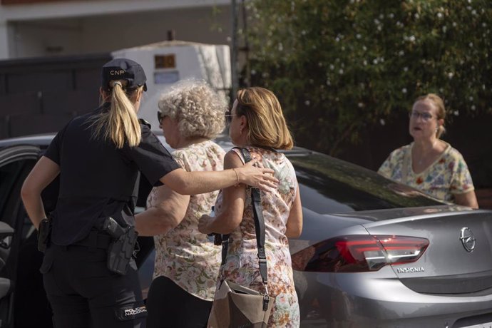 Familiares de la mujer en las inmediaciones donde un policía retirado se atrincheró en una vivienda en Alzira