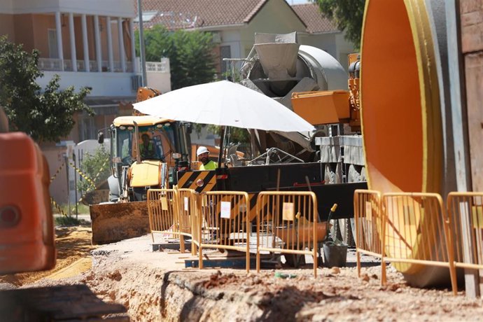 Trabajadores de una obra pública, con un parasol para resguardarse por momentos de las altas temperaturas.