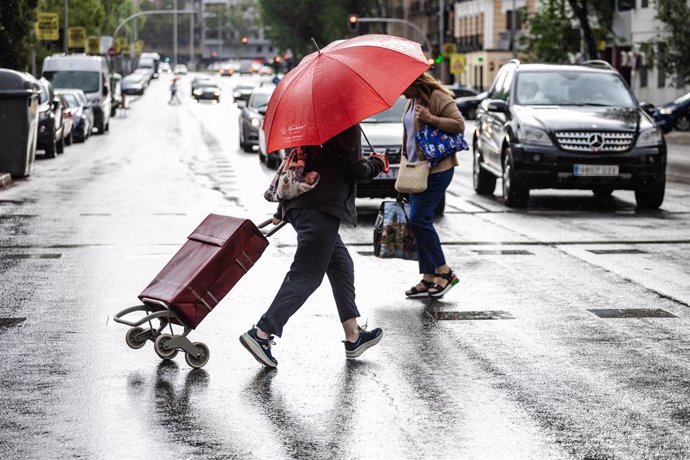 Dos personas caminan bajo la lluvia, a 2 de septiembre de 2023, en Madrid (España). La llegada de una DANA a España, que sucedió ayer 1 de septiembre, ha traído lluvias y un acusado descenso de las temperaturas este fin de semana, cuando las máximas no 