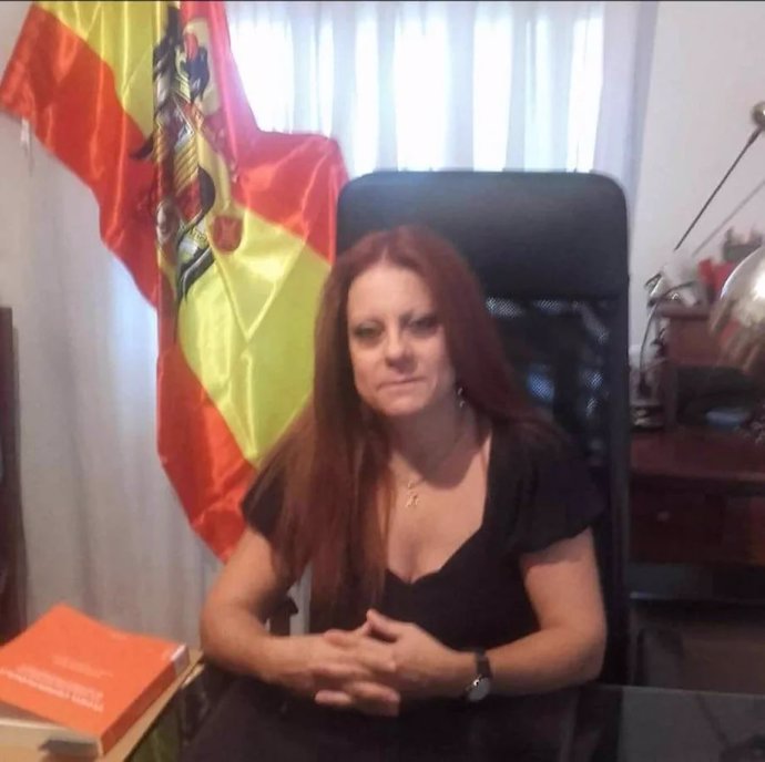 La directora general de Justicia de Aragón, Esmeralda Pastor, posa con la bandera franquista detrás.