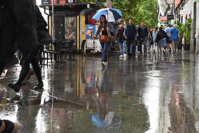 Archivo - Varias personas pasean bajo la lluvia, a 23 de mayo de 2023, en Madrid (España). La Agencia Estatal de Meteorología (Aemet) prevé lluvias en la región madrileña todo lo que queda de semana ocasionadas por una DANA (Depresión Aislada en Niveles