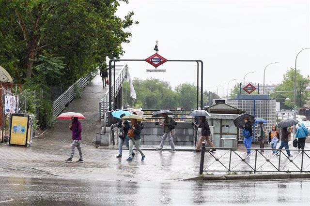 Archivo - Varias personas pasean bajo la lluvia, a 23 de mayo de 2023, en Madrid (España). 