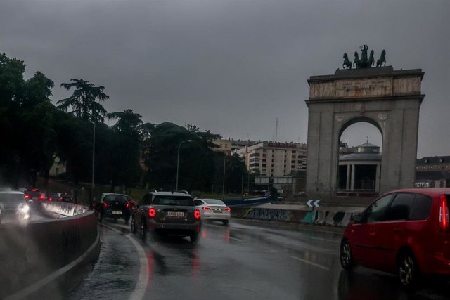 Archivo - Varios coches circulan bajo la lluvia.