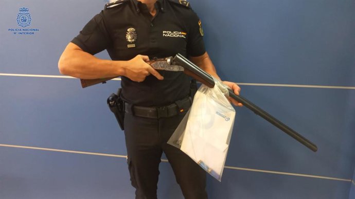 Un agente muestra la escopeta intervenida.