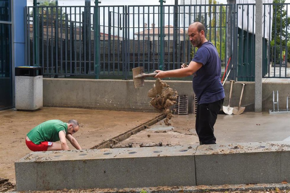 Varias personas limpian una cañería para evitar inundaciones, a 4 de septiembre de 2023, en Navalcarnero, Madrid (España). La zona más afectada por la DANA que ha descargado este fin de semana en la Comunidad de Madrid es el suroeste de la región, en lo
